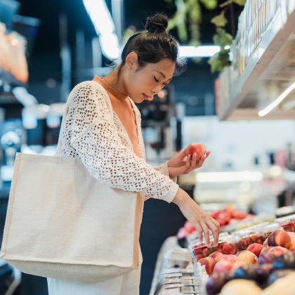 Woman grocery shopping choosing fruit