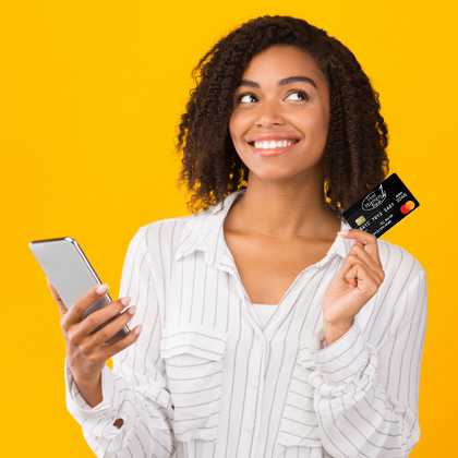Woman holding a phone and First Harrison Bank debit card with a yellow background